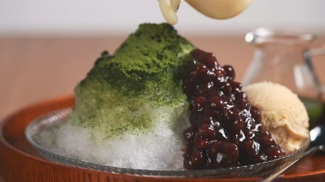 贅沢な抹茶かき氷に練乳をたっぷりとかける