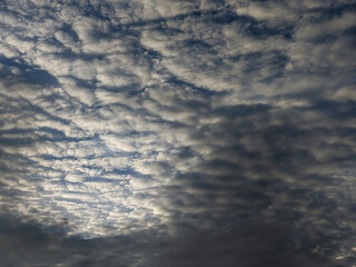 Obraz premium The altocumulus clouds in the sky look abstract and aesthetic against the blue sky. Altocumulus clouds are white clouds that have the shape of cotton wads that look very soft, fluffy and fluffy.