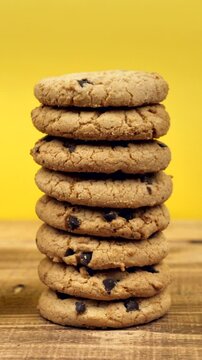 stack of chocolate oatmeal cookies on wooden table with yellow background. fade in and fade out