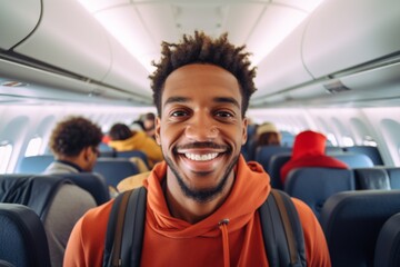 Obraz premium Portrait of a smiling African American man tourist standing in airplane aisle