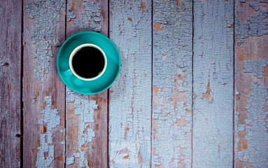 black coffee in a white ceramic cup on the old blue wooden floor