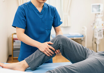 膝の運動療法を行う理学療法士