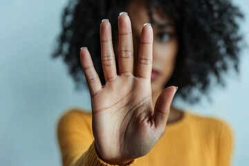 Woman holds up her hand in stop gesture, as symbol of resistance, defiance, or protest, struggling social issues, against racial discrimination, sexism, harassment, and gender-based violence, close up