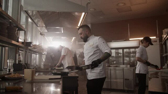 Man chef cooking dishes in restaurant kitchen