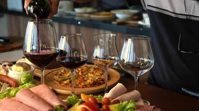 Hand Pouring Wine with a lot of foods at the back