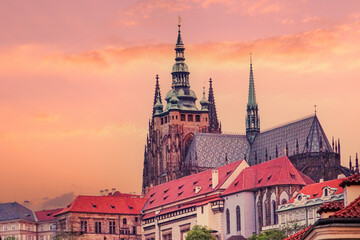 Fototapeta premium The majestic spires of St. Vitus Cathedral in Prague, Czech Republic, part of the historic Prague Castle complex, dominate the skyline under a colorful, possibly dawn , sky filled with soft light.