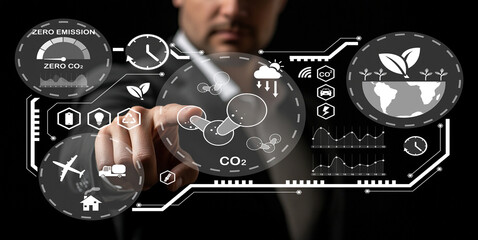 Businessman Interacting with Futuristic Touchscreen Display for Environmental Sustainability and Zero Emission Concept in Dark Setting
