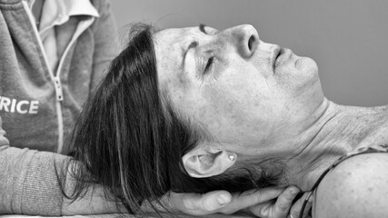 Physiotherapist performs neck massage on a woman for pain relief and relaxation