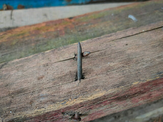 Close-up of a rusty nail sticking out of a piece of wood