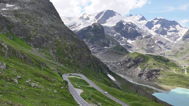 Flight towards Stein Glacier and mountain panorama revealing the serpentine road of mountain pass Susten Pass in the Swiss Alps, Switzerland