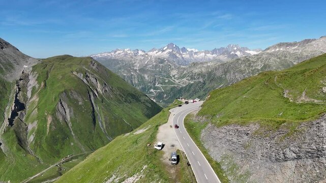 Flight over serpentine road at mountain pass Furka Pass towards mountain Finsteraarhorn panorama in the Swiss Alps, Switzerland