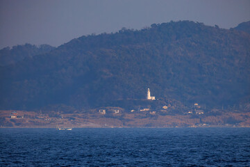 Fototapeta premium 夕日に染まる房総半島。 白い灯台や漁船も見える。東京湾から眺める美しい夕陽。 東海汽船東京湾～伊豆諸島八丈島、太平洋航路の橘丸船上-2025 