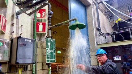 Safety engineer testing an emergency shower inside an industrial facility