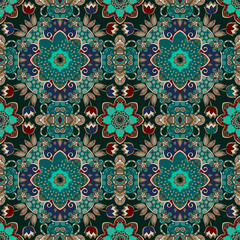 Seamless floral pattern in folk style in turquoise, blue, red and beige tones on a black background in vector.