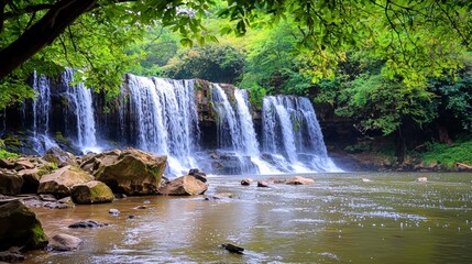 Obraz premium A serene jungle waterfall cascades over mossy rocks into a tranquil river, creating a breathtaking natural scene perfect for travel brochures or nature documentaries with ample