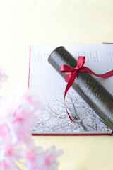 卒業証書と卒業アルバムと桜の花びら