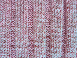 Pink knitting in progress. knitting needles and neat loops creating a textured pattern. a ball of soft wool yarn creating a cozy atmosphere. themes of handicrafts, creativity, knitting and hobbies.