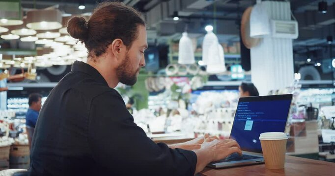 Elearning developer. Programmer creating e-learning modules educational content on his computer. Man sitting in cafe looking at screen and typing code. E-learning developer found a solution of issue