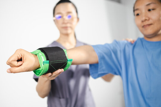 Physical therapy, Physical therapy is essential for recovery and rehabilitation as therapist assists patient with arm exercises to improve strength and mobility