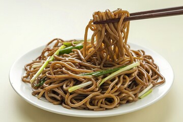 A photo of a plate of brown, twisted and intertwined noodles in a soy sauce