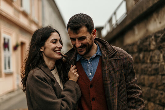 Happy couple laughing and walking on a city street