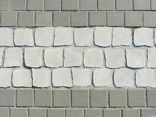 Paved zebra crossing. paved surface with white stones hinting at a zebra crossing. Structure and marking provide orientation in the sidewalk area.