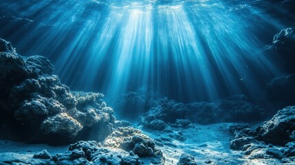 Obraz premium Underwater shot of sunbeams shining through the blue ocean water. It is perfect for marine life or ocean environmental conservation content.