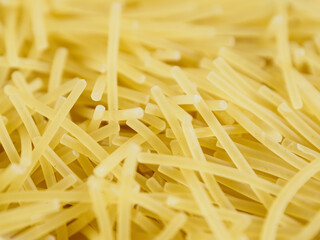 Close-up of small, thin vermicelli filini pasta. Delicate strands create a fine, textured food background.