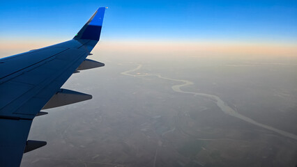 Obraz premium Looking out of an Airplane Window at Sunset while in Flight