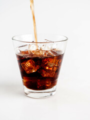 Pouring Cola with Ice in Glass on White Background