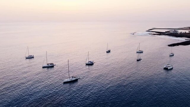 Scenic ocean sunset, yachts anchored peacefully off the coast of Playas de Troya