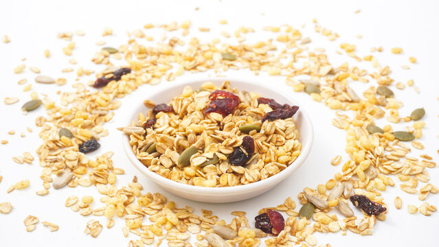 Delicious granola blend with oats, nuts, and dried fruits on bowl isolated on white background