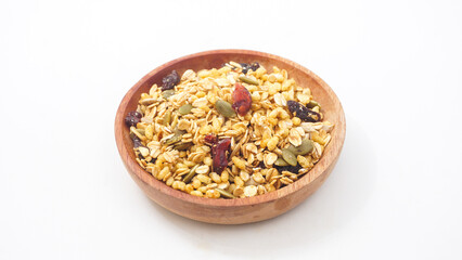 Healthy breakfast granola with oats, nuts, and dried fruits on wooden spoon isolated on white...