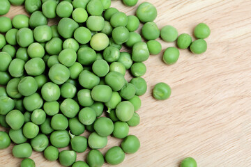 Green peas on wooden board table background