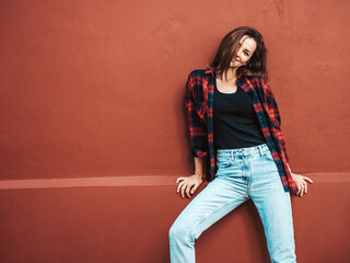 Portrait of beautiful smiling model. Female dressed in summer hipster checkered shirt and jeans....