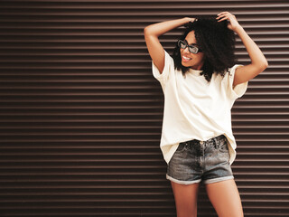 Beautiful woman with afro curls hairstyle. Smiling hipster model in white t-shirt. Carefree female...