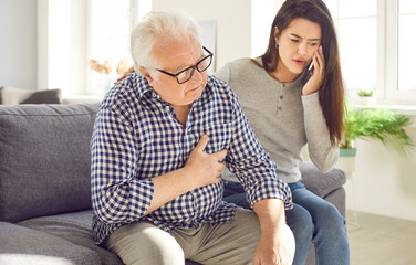 Worried young woman daughter or granddaughter calling emergency service to help save life of old...