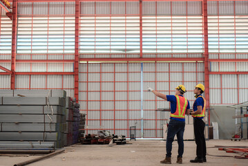 Civil Engineer or Construction engineer and foreman having Check project progress and discussion together for a building plan and architecture development at the construction site of factory