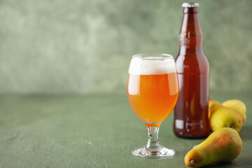 Boozy Refresing Cold Hard Pear Cider or Craft Fruit Beer in a Pint Glass on wooden table. Copy space