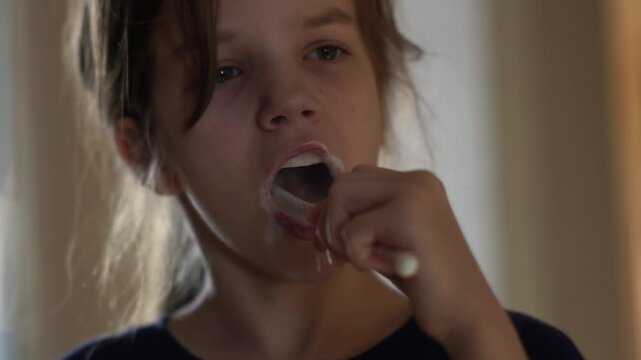 The girl brushes her teeth for the purpose of recovery, oral hygiene. The child takes care of dental health.