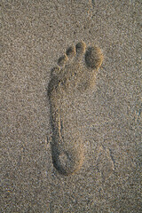 a footprint of a person's foot in the sand on the beach