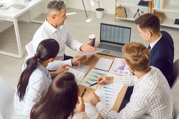Diverse business team at meeting table to discuss financial report, mentor training group of...