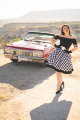 beautiful girl in a retro dress at sunrise happy posing on the background of the mountain landscape...