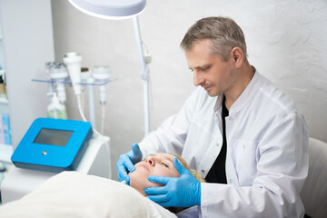 girl at a cosmetologist man during treatment procedures