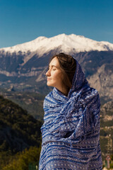 Naklejka premium a beautiful girl on the background of the mountains is covered with a blanket