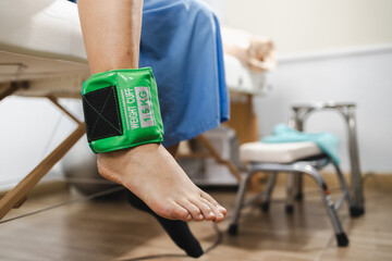 person is using weight cuff for physical therapy to enhance strength and mobility during rehabilitation exercises