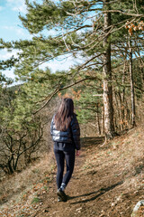 Relaxed woman breathing fresh air in a green pine forest and making breathing exercises 