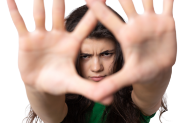 Portrait of a serious young woman showing stop gesture with her palm over white background