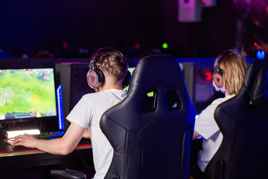 Guys are playing multiplayer online battle arena strategy game. Male players with professional gaming headset. E-sport men are playing first-person shooter game, showcasing their pro gaming skills