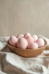 Minimal pastel eggs in wooden bowl on soft fabric